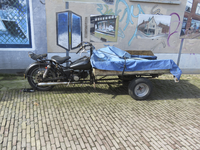 908195 Afbeelding van een motorbakfiets, geparkeerd op de Van Asch van Wijckstraat te Utrecht, met op de achtergrond ...